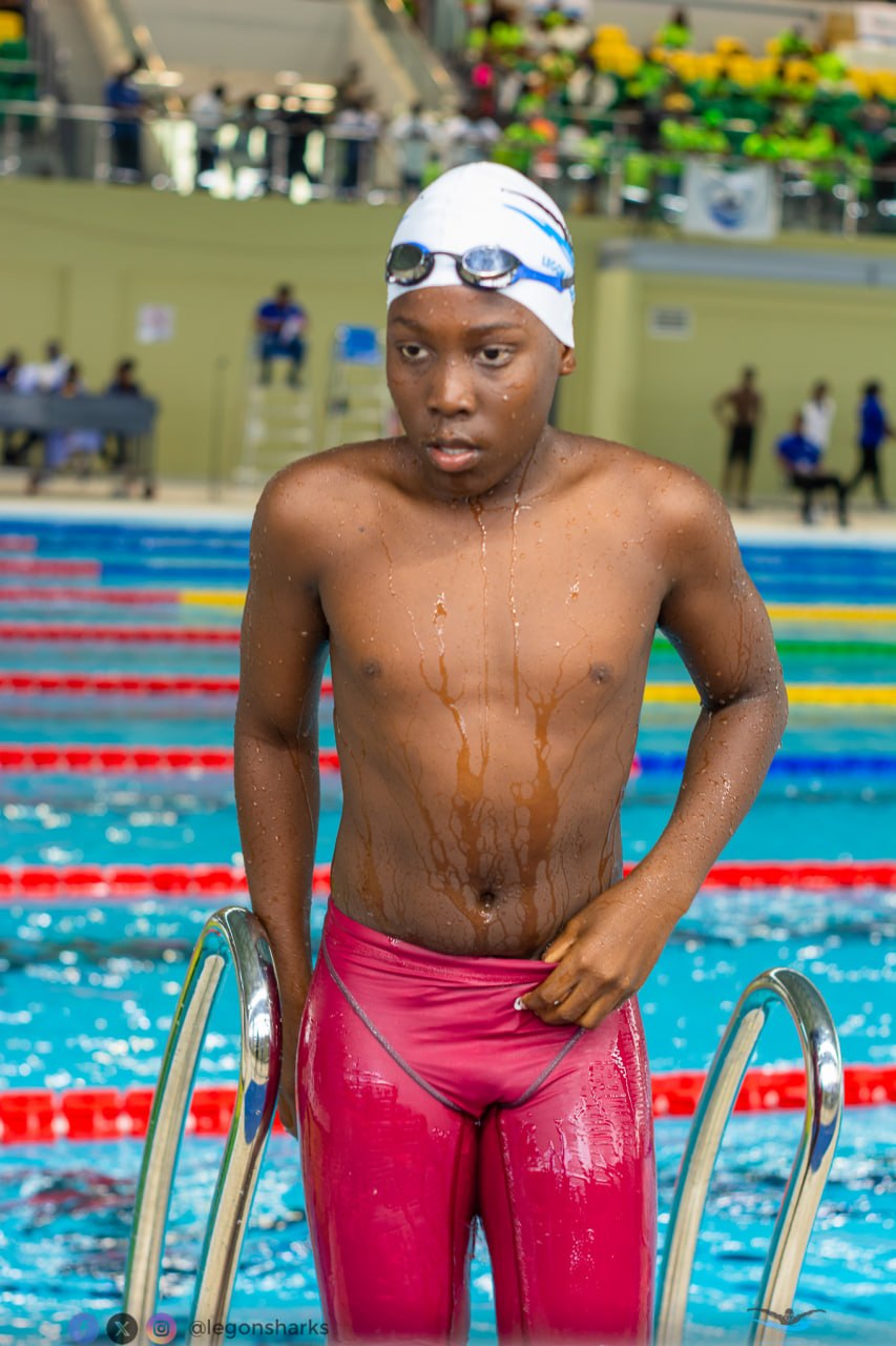 Young male swimmer in red jammers climbing out of pool