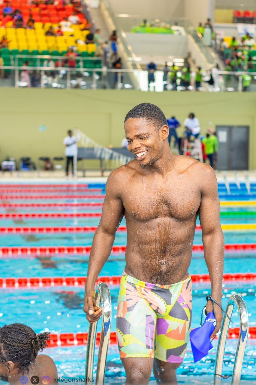 Adult male swimmer smiling climbing out of pool colorful jammers