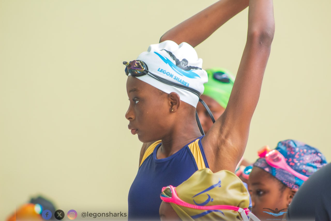 Young Legon Sharks swimmer stretching arm raised pre-race