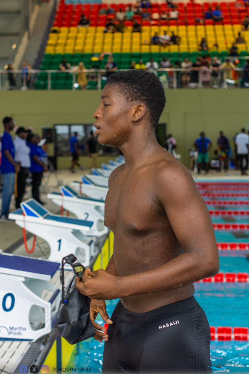 Teenage male swimmer post-race by starting blocks