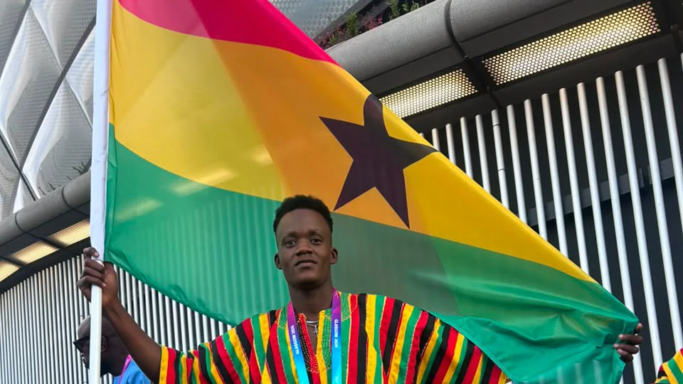 Promise Aheto carrying the Ghana flag in Glasgow